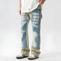 Retro blue and yellow patchwork jeans with splash-ink damaged design on a mid-waist fit.