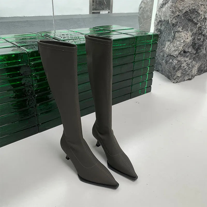 Black women's pointed toe below-knee boots with stiletto heel and back zipper on a white background.