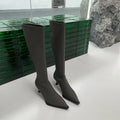 Black women's pointed toe below-knee boots with stiletto heel and back zipper on a white background.