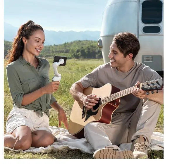 Silver and black magnetic PTZ gimbal for smartphones showing magnetic phone mount and control buttons.