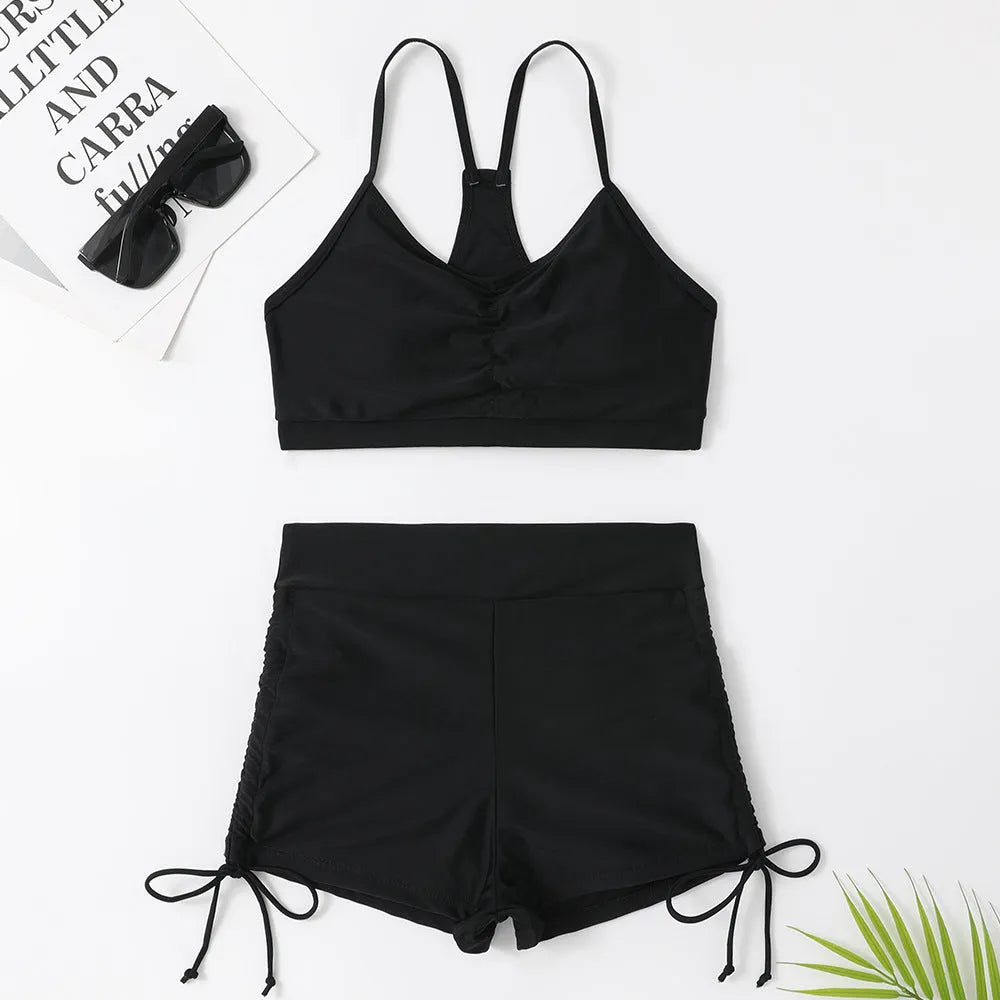 Women's black high waist split bikini swimsuit top and shorts laid flat.