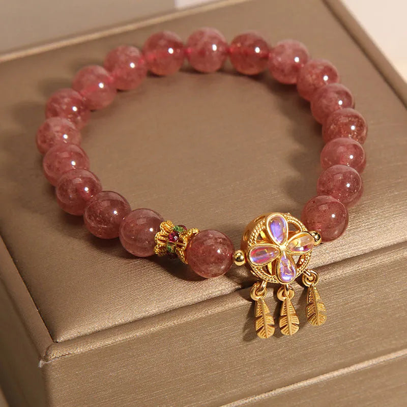 Women's Strawberry Quartz crystal bracelet with a four leaf clover dream catcher ball pendant.