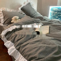 Washed cotton linen four-piece bedding set in a solid colour, showing quilt cover, pillowcases, and sheet.
