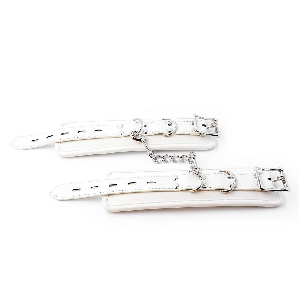 White PU sponge bondage restraint set showing handcuffs, footcuffs, and a neck collar.