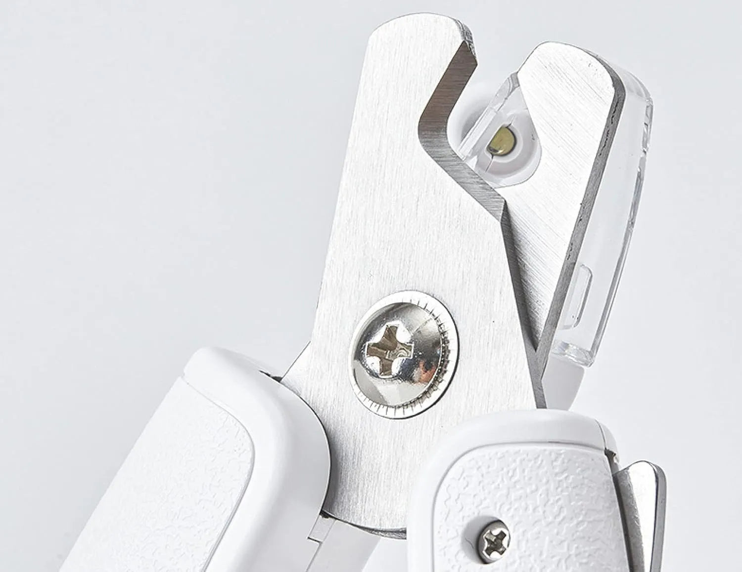 White LED pet nail clippers with transparent guard, triangular blade, and anti-slip handle next to a filing tool.