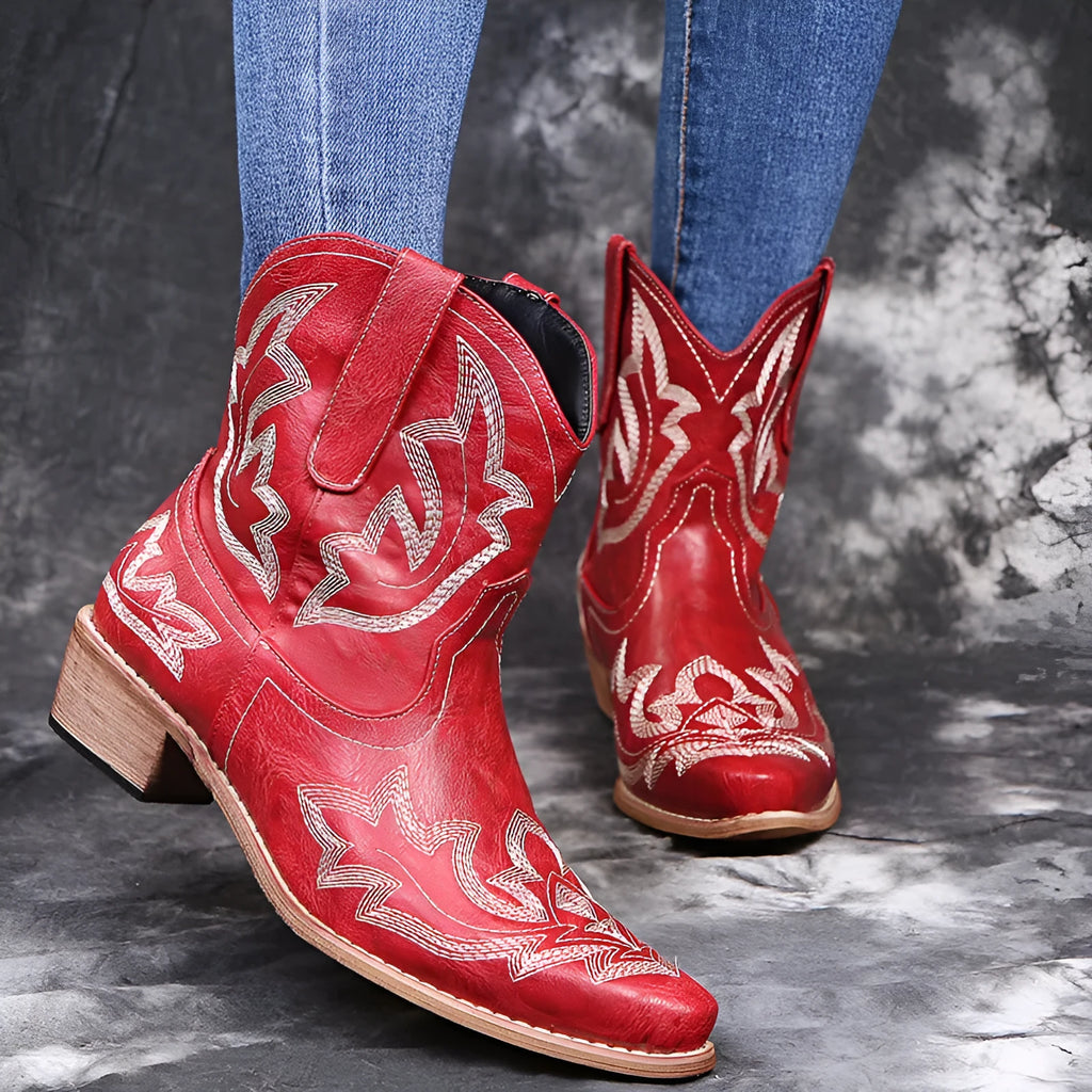 Women's blue embroidered cowboy boots with wedge heel and pointed toe on a white background.