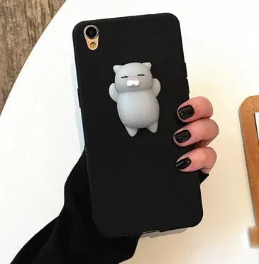 A soft pink silicone iPhone case featuring a raised 3D cartoon cat design on the back.