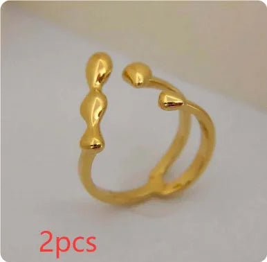 Open circle brass fashion ring with spherical beads in gold tone on a hand.