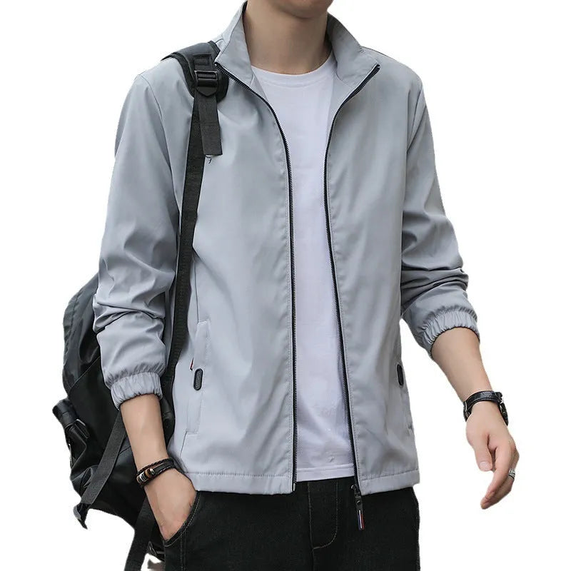 Man wearing a loose-fit black lapel jacket, Korean-style casual autumn coat with zipper pockets.