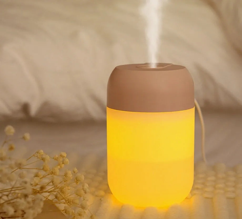 White cylindrical USB-powered small humidifier with aromatherapy function on wooden desk