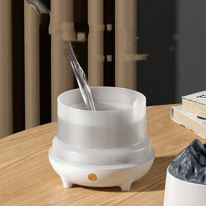 White volcano-shaped humidifier with flaming mountain design on wooden surface