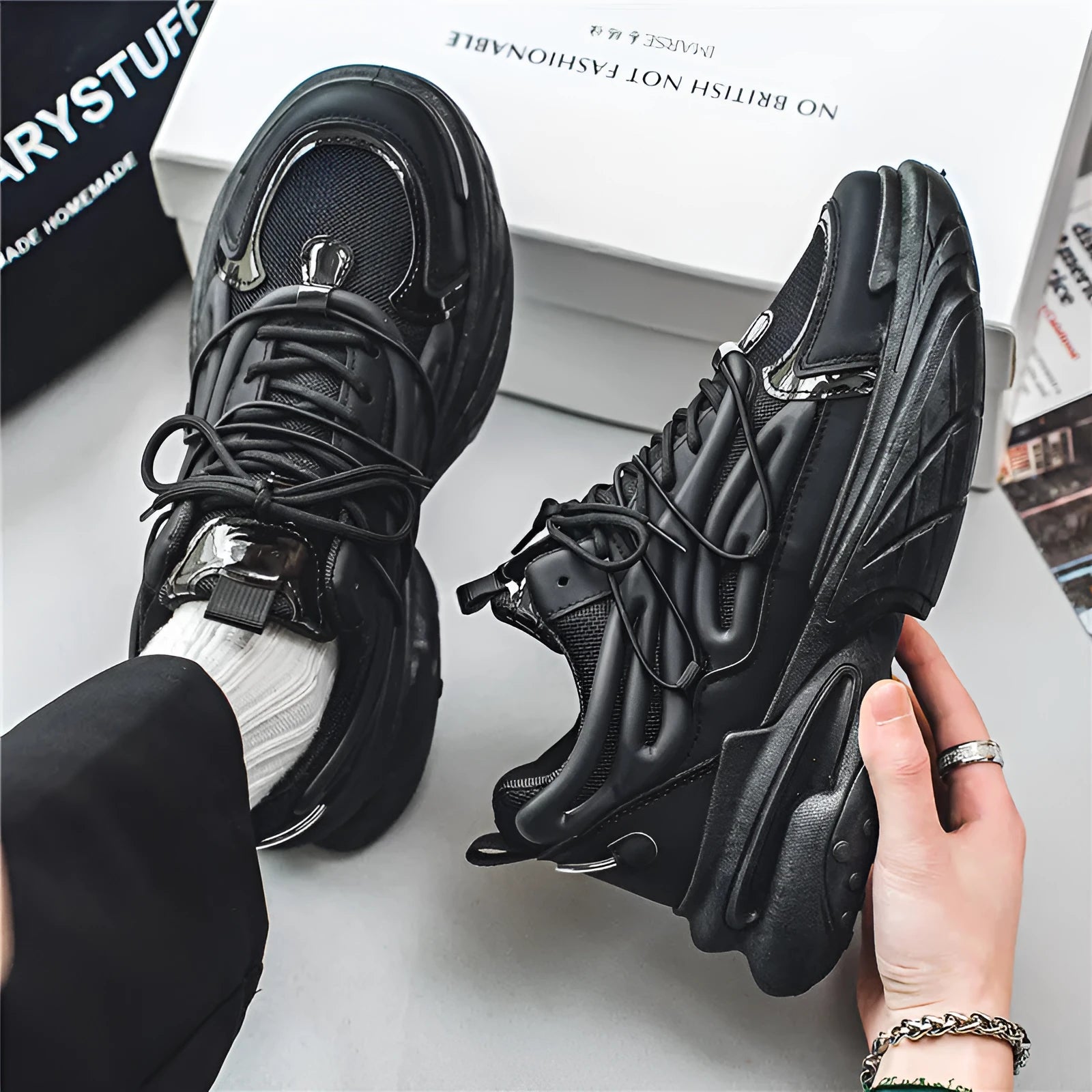 Men's beige and black low-top lace-up sneakers with mesh upper and rubber platform sole.