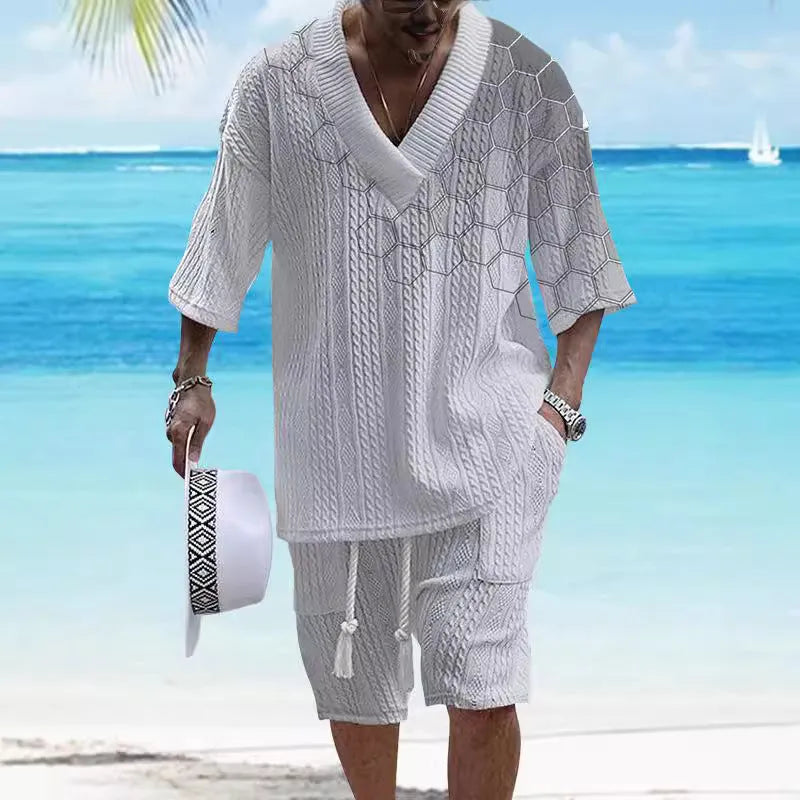 Man wearing a grey printed knitted short-sleeved top with drop shoulders and matching shorts, a casual two-piece suit set.