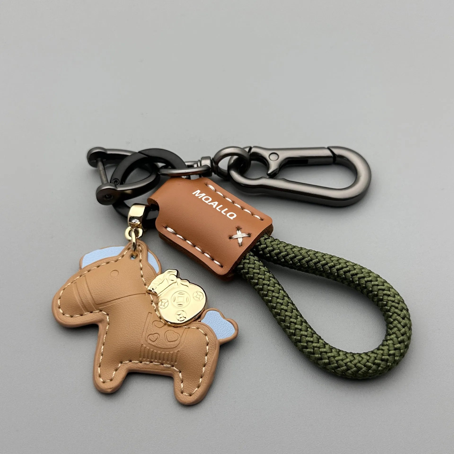 Handmade brown cowhide key pendant with a green flannel rope and a gold-toned horse-shaped buckle.