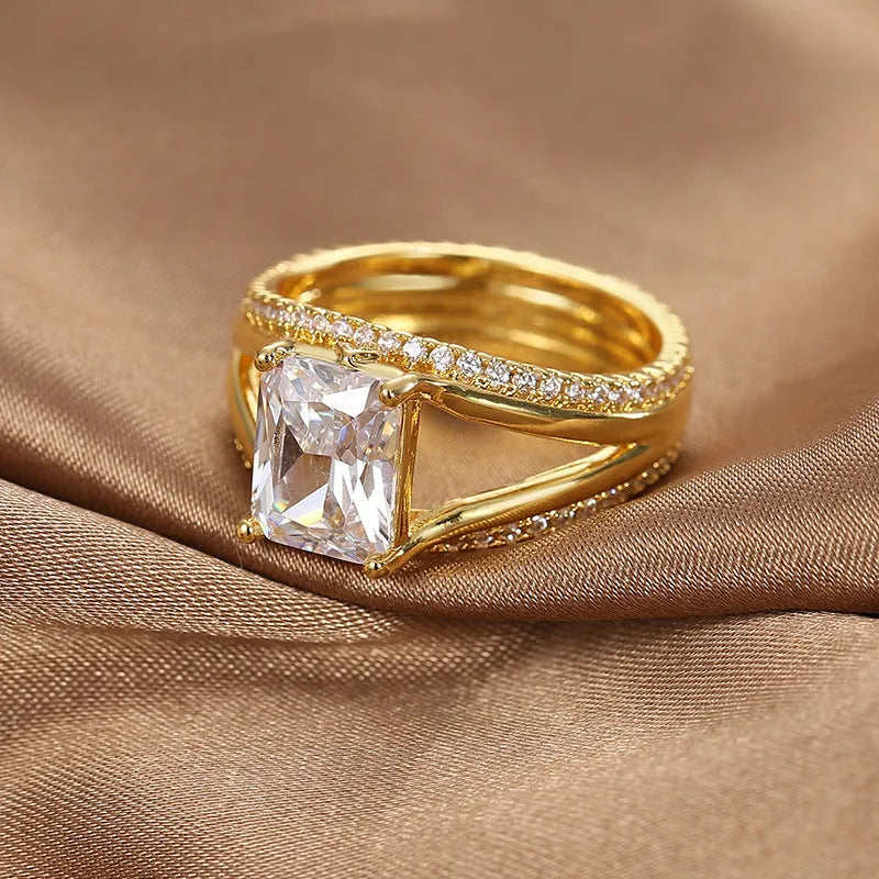 Geometric gold-coloured women's ring with a square zircon stone on a copper band.
