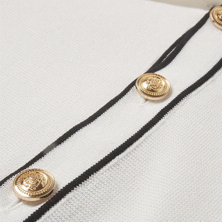 White short sleeve cardigan with dark contrast lapels on a hanger.