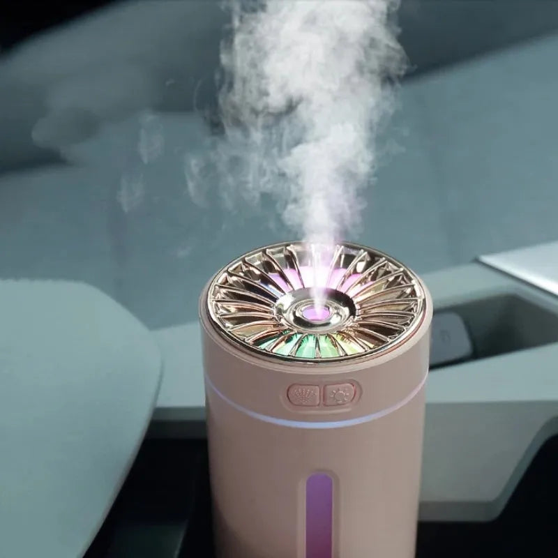 Black and white portable USB rechargeable humidifier with colourful LED lights on a car cup holder.