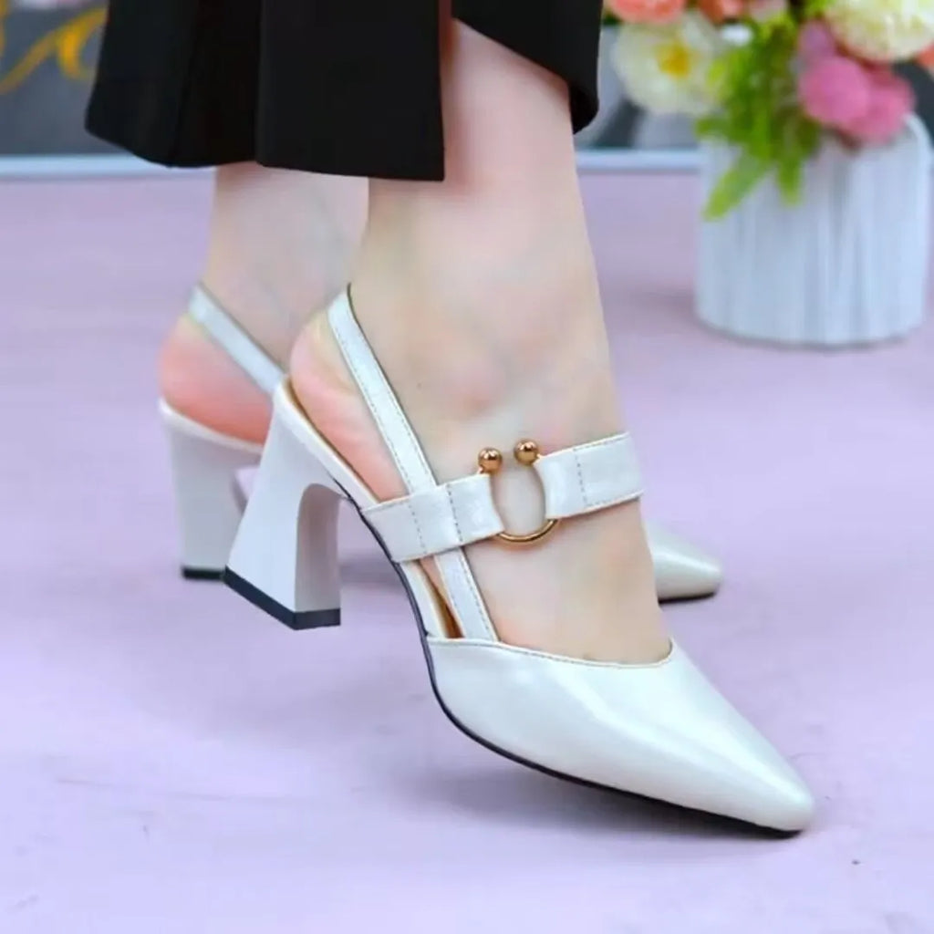 Women's apricot coloured closed toe backless leather sandals with a chunky high heel on a white background.
