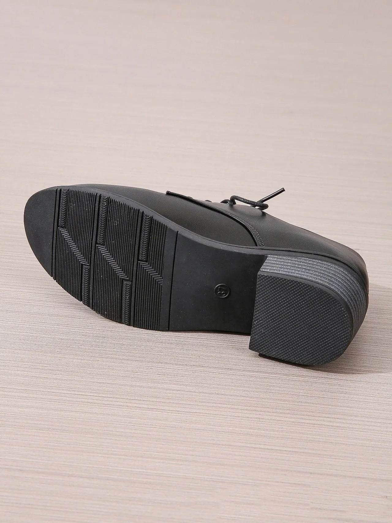 Black women's low-top work shoes with a chunky rubber heel and pointed toe.