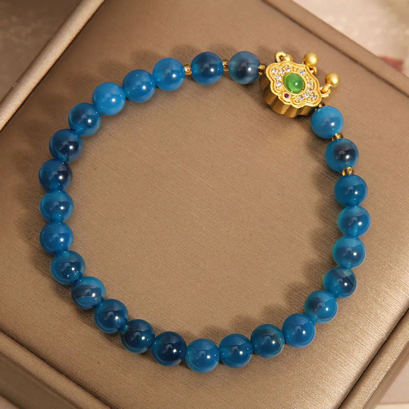 Blue agate safety lock pendant on a women's crystal bracelet with alloy-inlaid gemstones and rhinestones.
