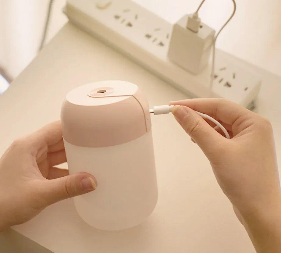 White cylindrical USB-powered small humidifier with aromatherapy function on wooden desk