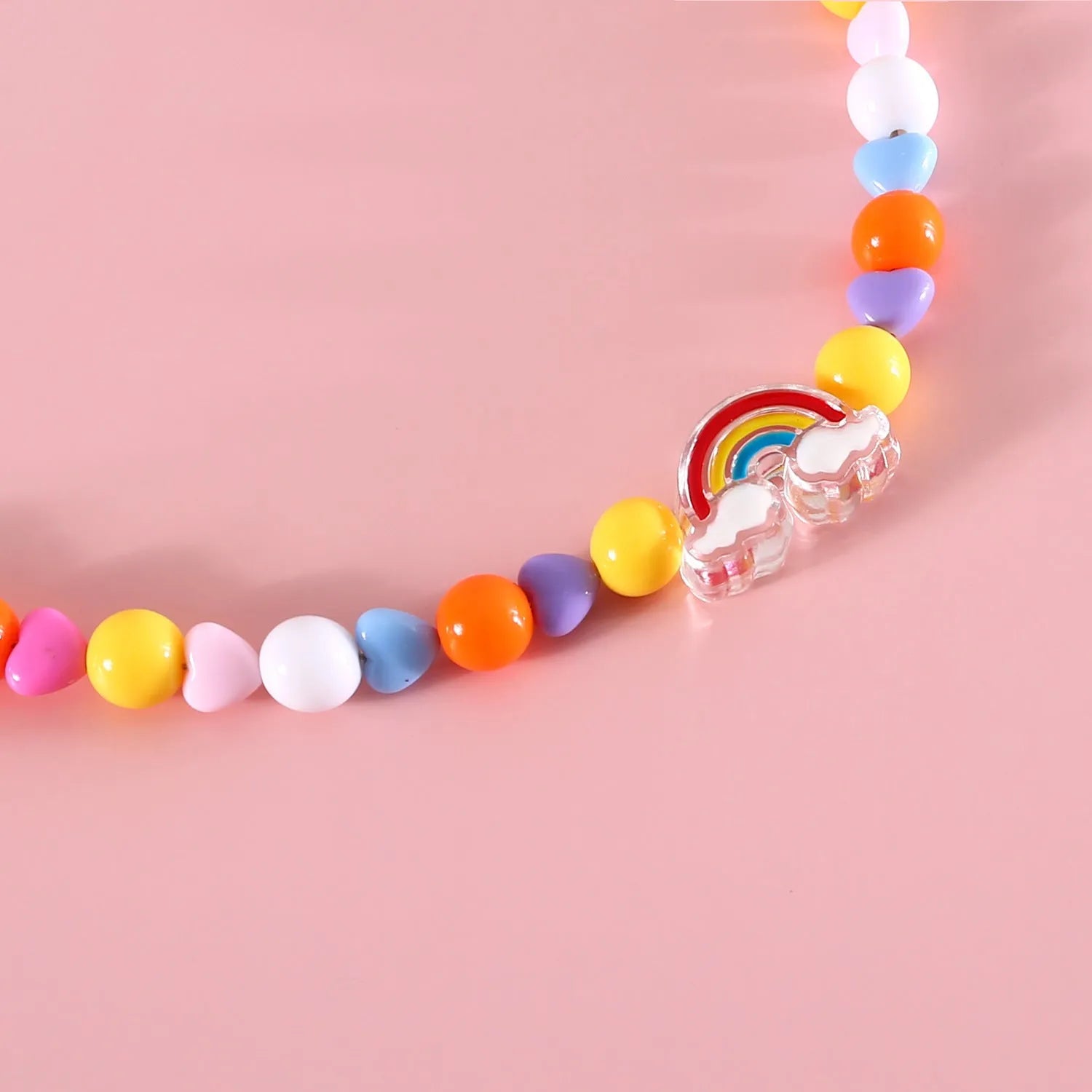 Adjustable colourful bead cat necklace in small flower, rainbow, or peach design on a white background.