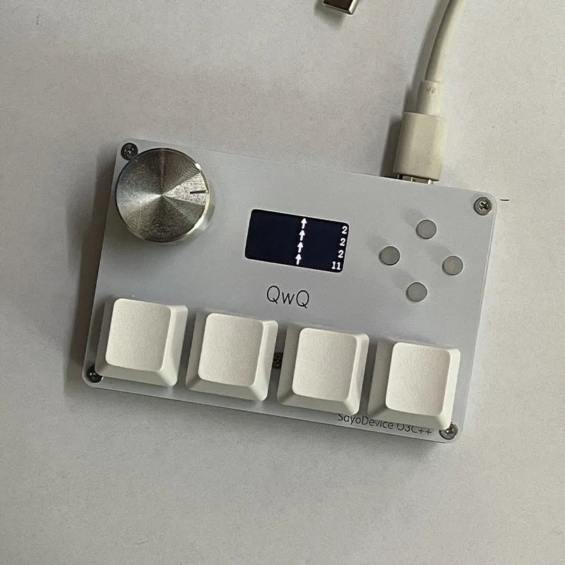 Customisable magnetic axis gaming keypad with programmable knob and colour IPS screen on desk.