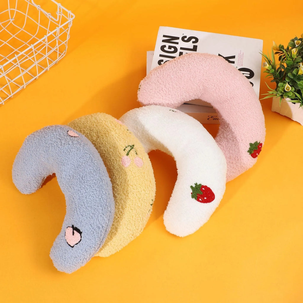 Blue half moon U-shaped cloth pillow for pets in a crate.