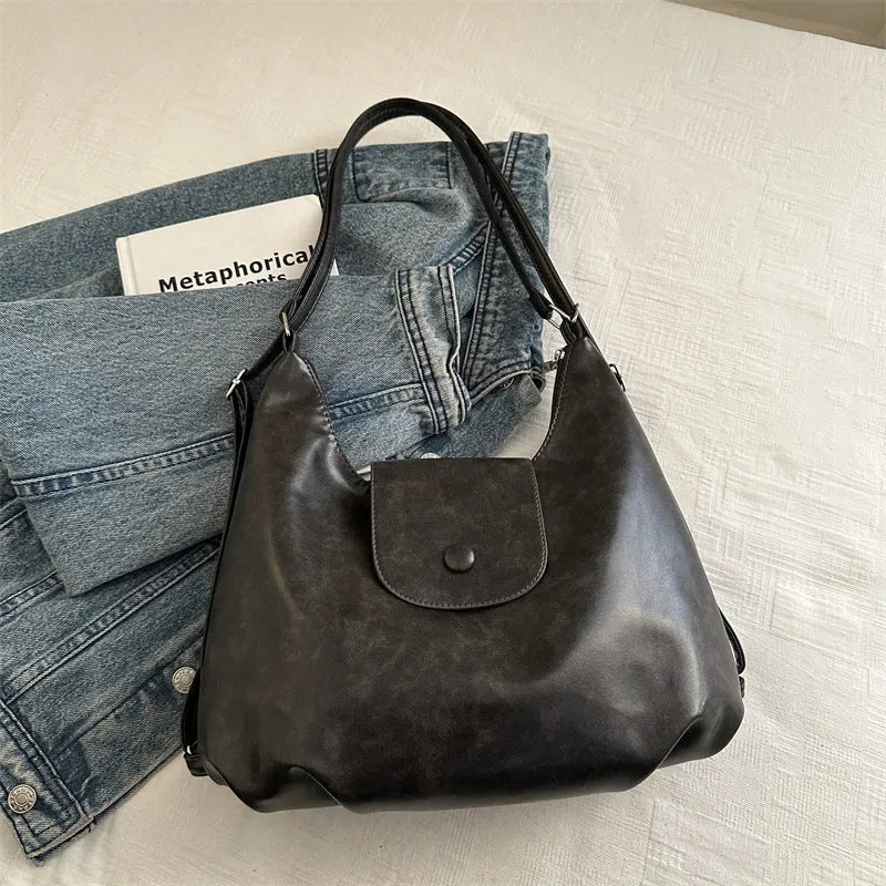 Textured PU leather commuter shoulder backpack in horizontal square shape with single strap and mobile phone compartment