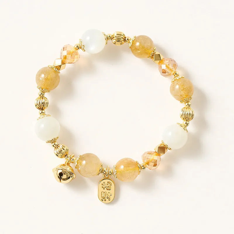 Gold electroplated bracelet with rutilated quartz crystals and a central ringing bell charm