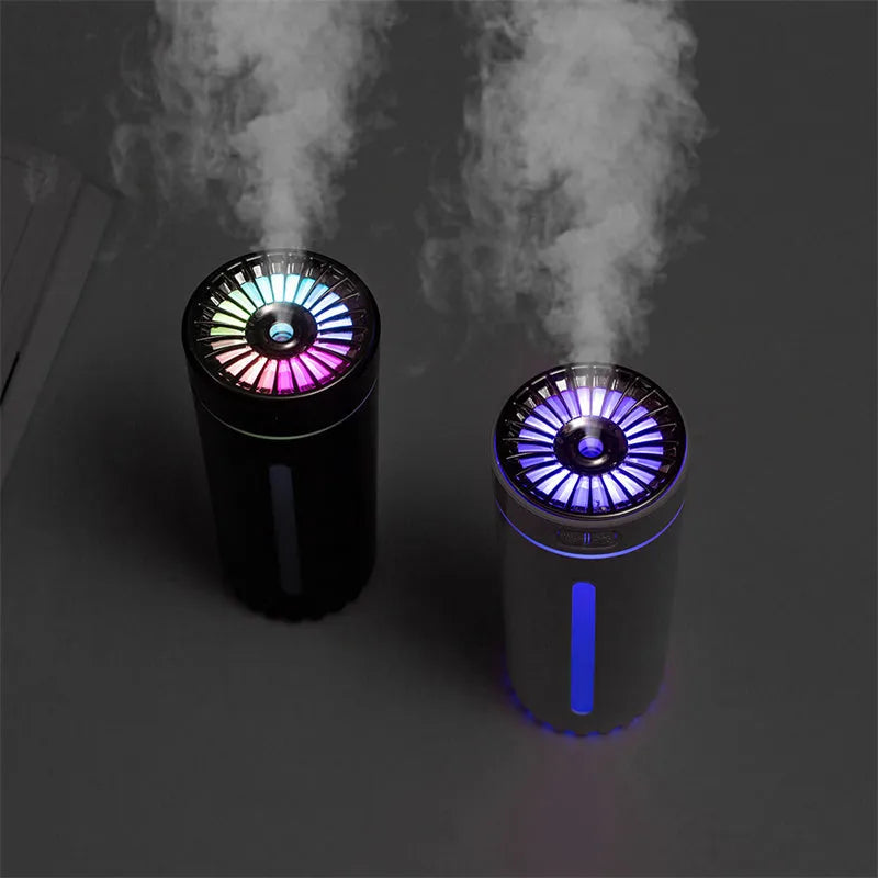 Black and white portable USB rechargeable humidifier with colourful LED lights on a car cup holder.