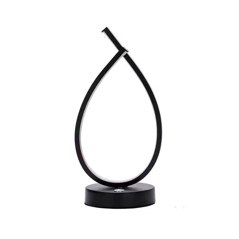 Modern black water drop shaped USB table lamp with touch control on wooden bedside table