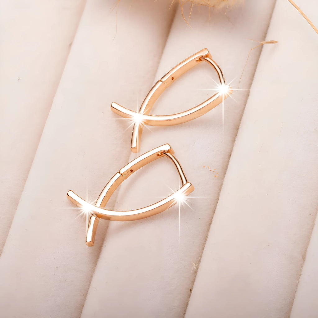 Rose gold coloured cross shaped earrings on a copper base.