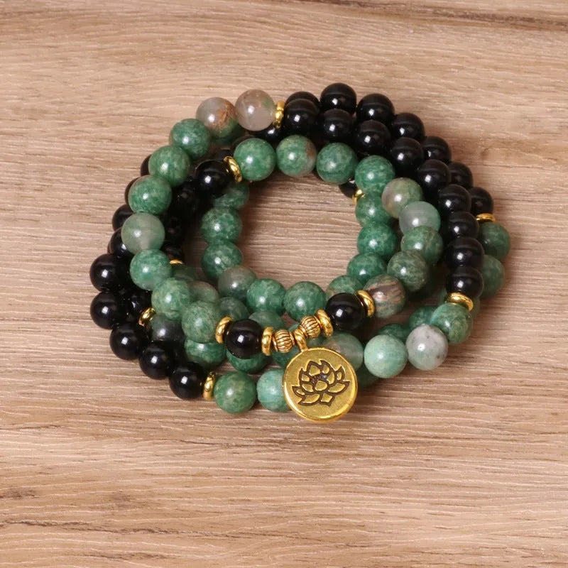 Green and black alloy elastic beaded bracelet on a wrist.