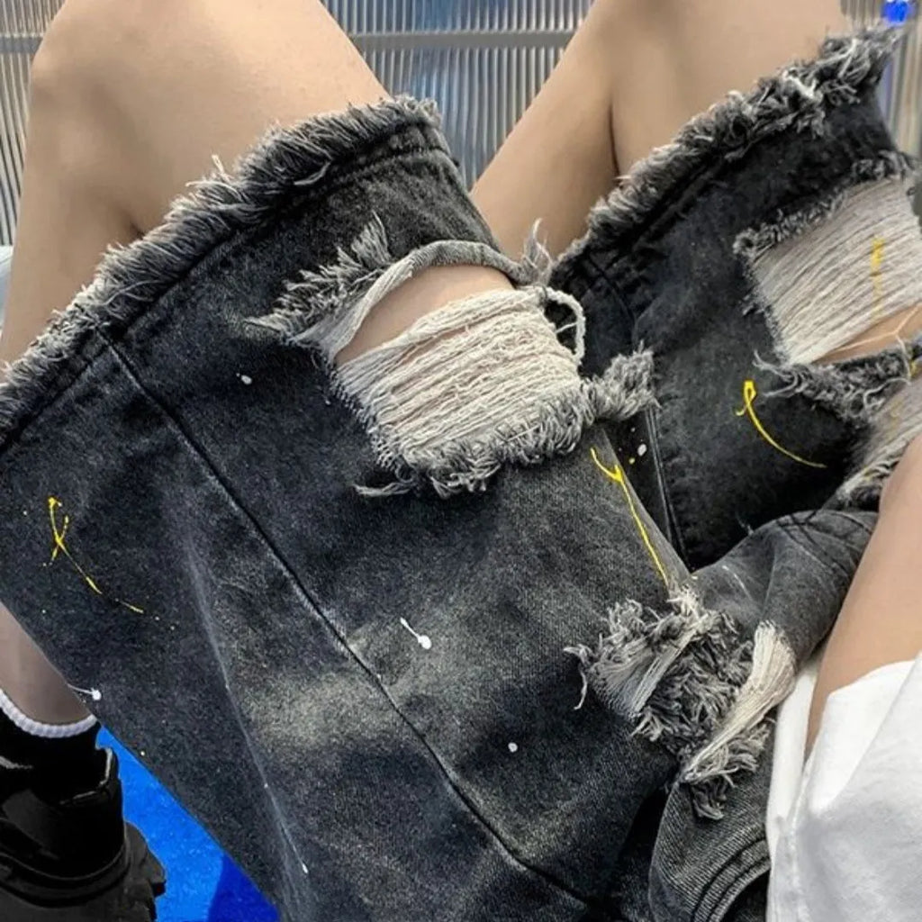 Man wearing loose-fit light blue denim shorts with a water-washed finish and distressed holes.