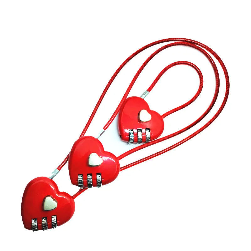 Peach heart shaped combination lock with a black steel rope cable coiled on a table.