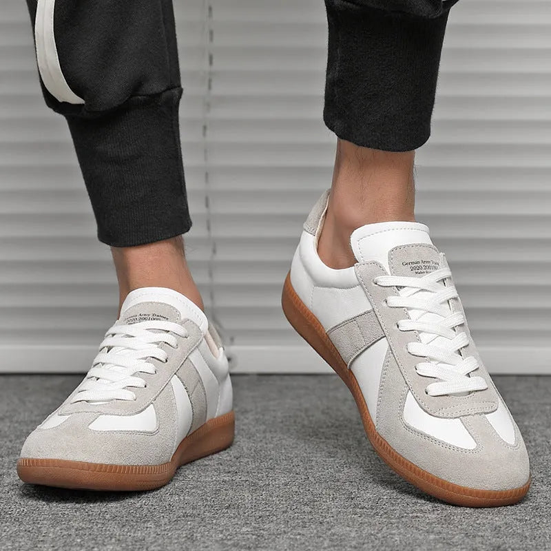 White Japanese-style retro low-top unisex sneakers with round toe and flat rubber sole on a plain background.