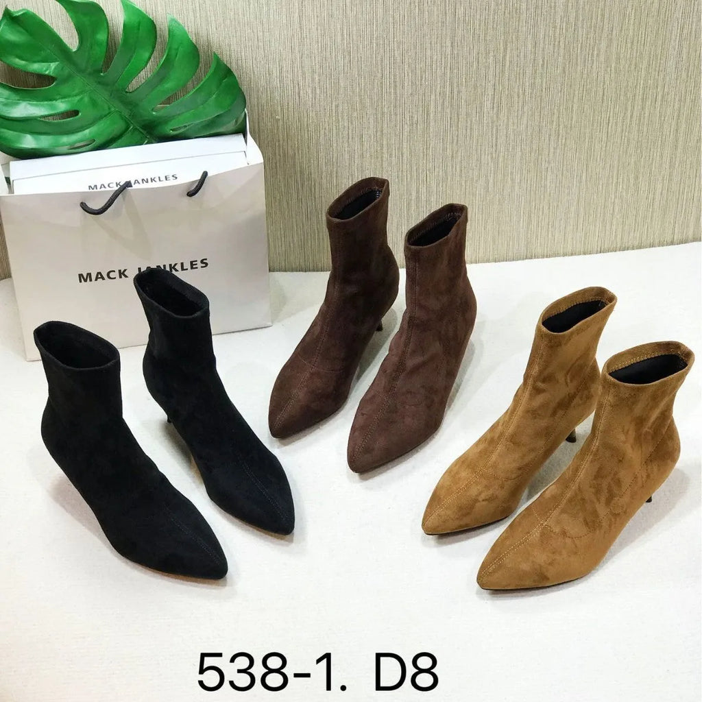 Black pointed toe stiletto heel ankle boots with a calf-high shaft on a neutral background.