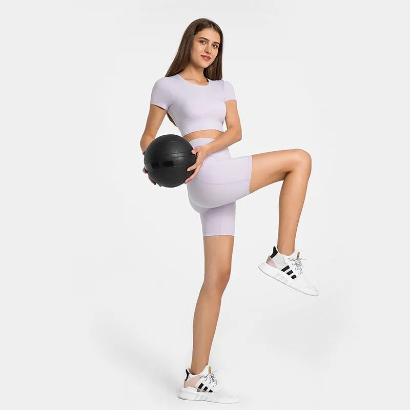 Women's tight-fit cotton blend sports shorts in short fifth pants length on a neutral background.