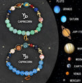 Set of twelve natural stone beaded bracelets with zodiac symbols on adjustable cords.