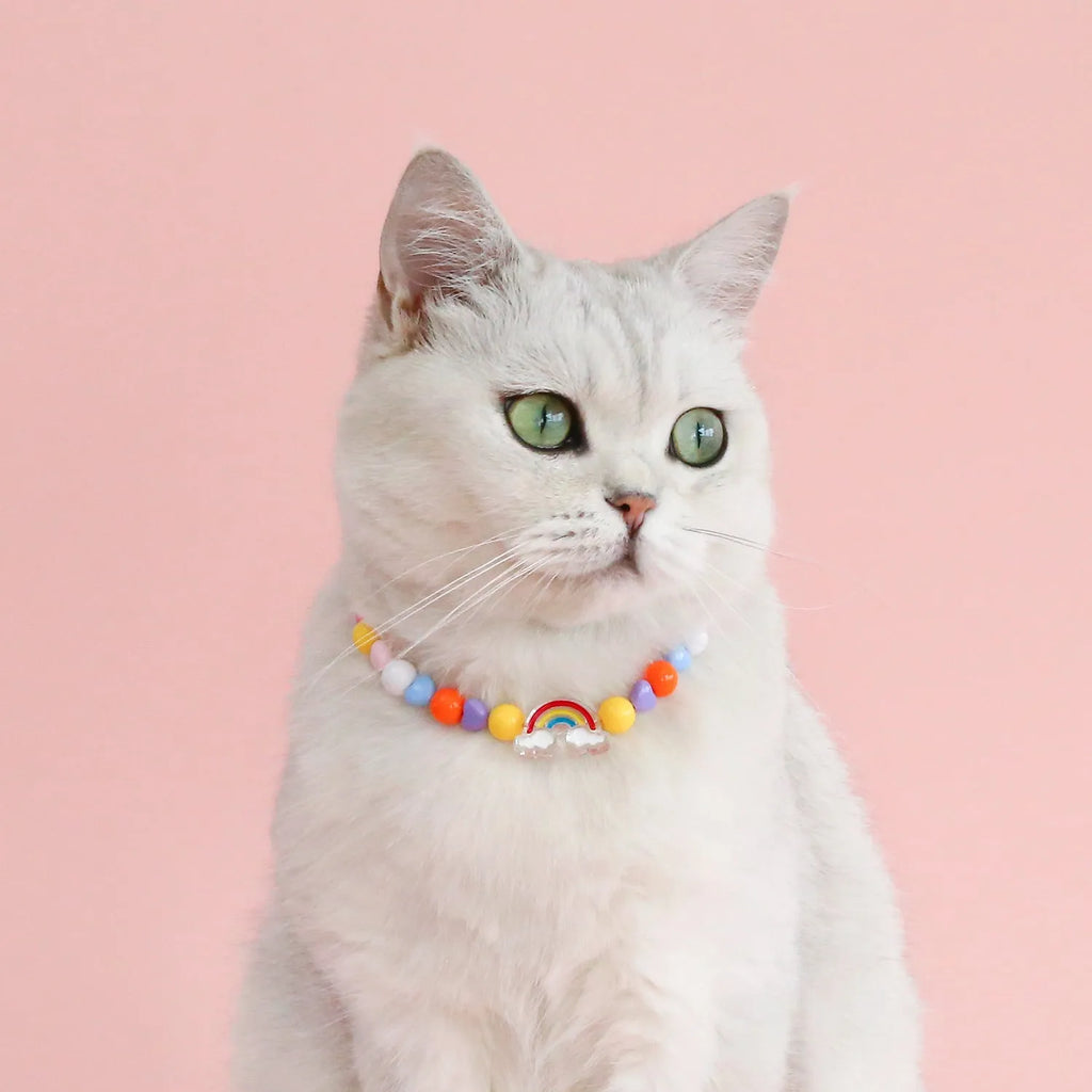 Adjustable colourful bead cat necklace in small flower, rainbow, or peach design on a white background.