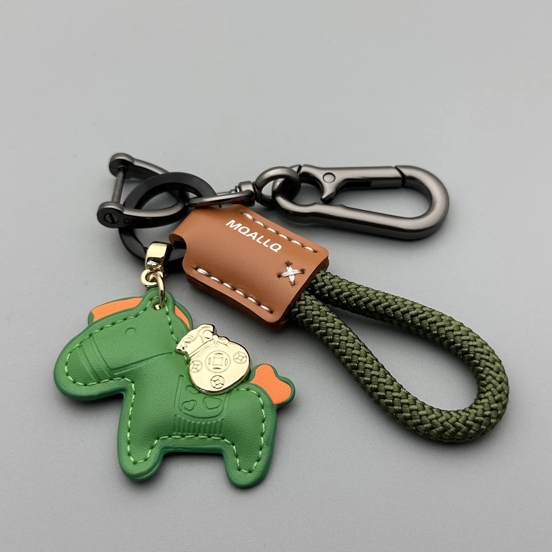 Handmade brown cowhide key pendant with a green flannel rope and a gold-toned horse-shaped buckle.