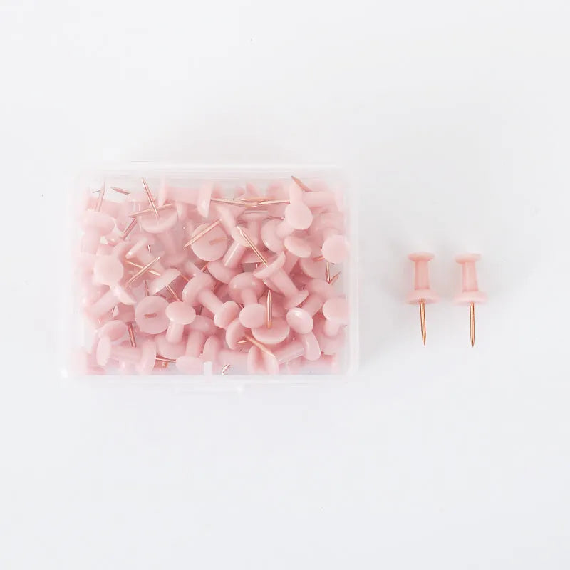 50-piece pack of Morandi colour push pins with three different pin head styles on a cork board.