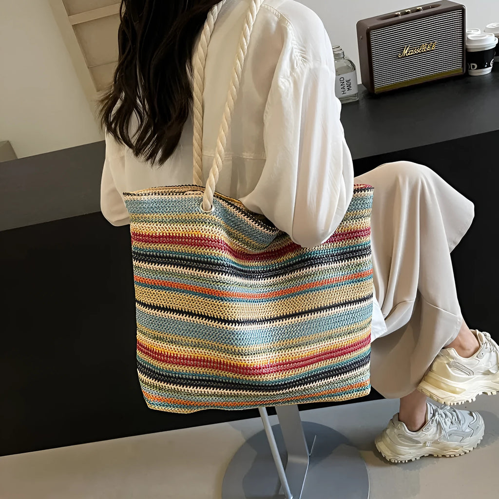 Blue woven straw and nylon shoulder bag with a single strap.