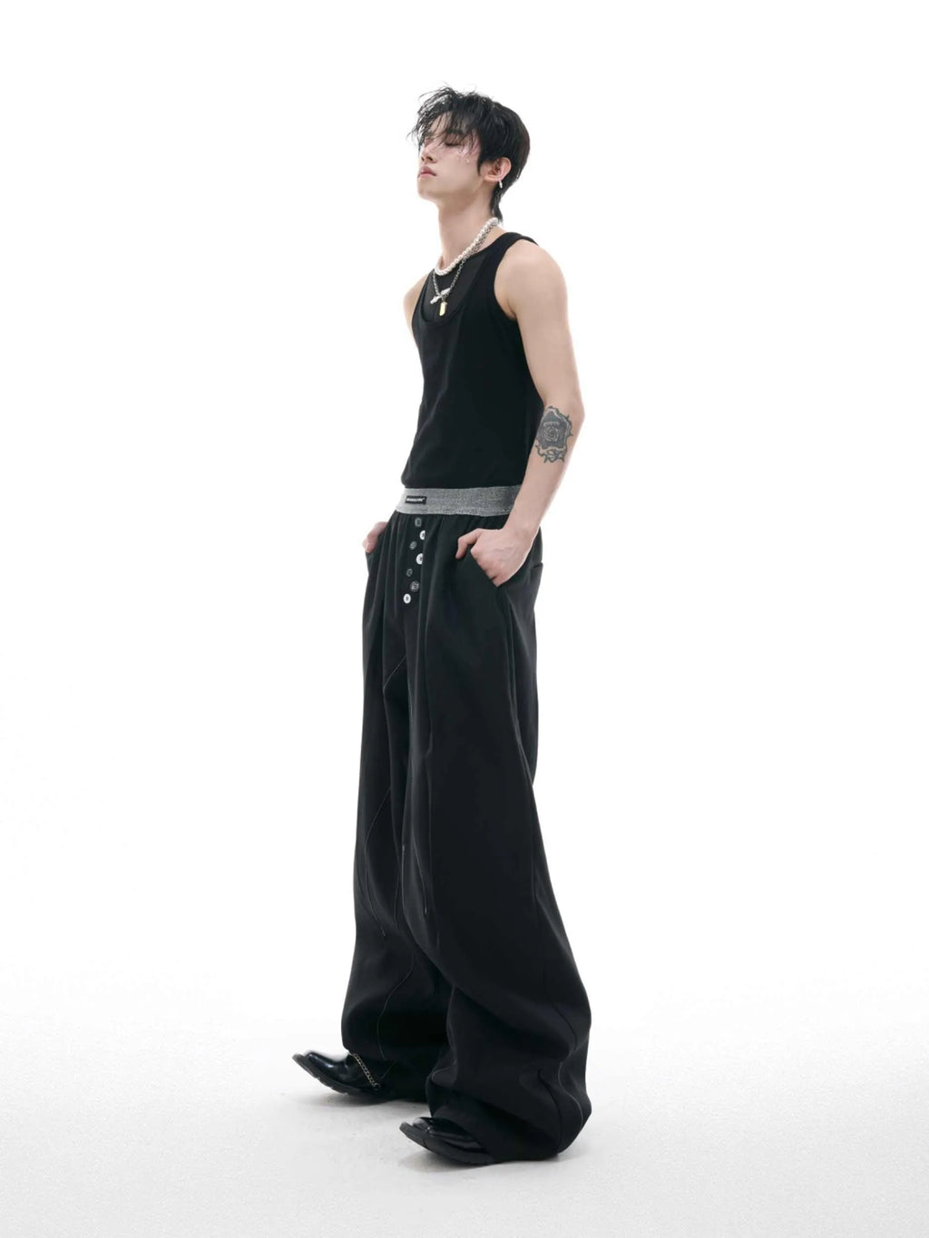 Men's high-waisted straight-leg casual trousers in black with button fly front, showing relaxed fit.