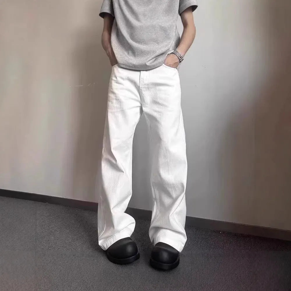 A pair of men's straight-leg white jeans with a mid-rise waist and zipper fly on a plain background.