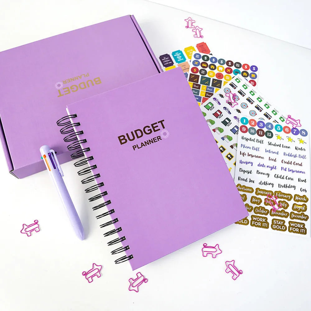 Purple coil-bound budget notebook with financial planning stickers and paper clips for monthly money management