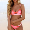Women's black and white dot and red and white stripe polyester bikini swimsuit set on a mannequin.