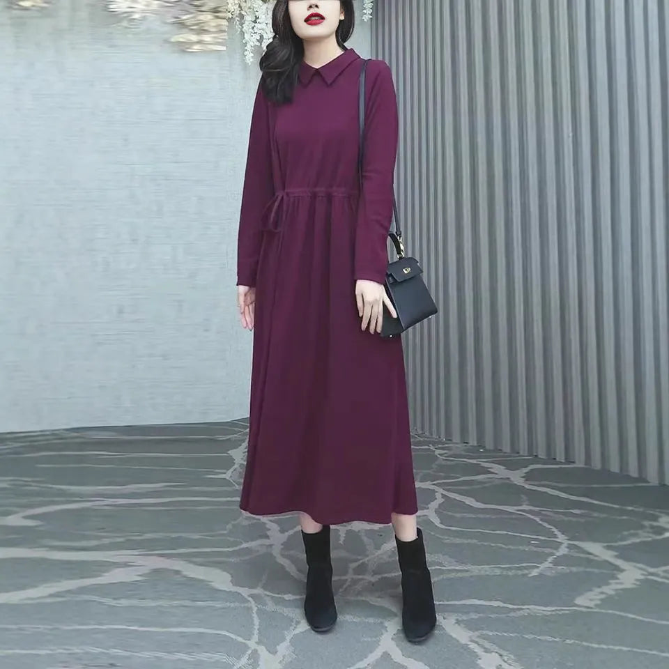 Purplish red women's plus size long sleeve dress with a long skirt, shown on a hanger.