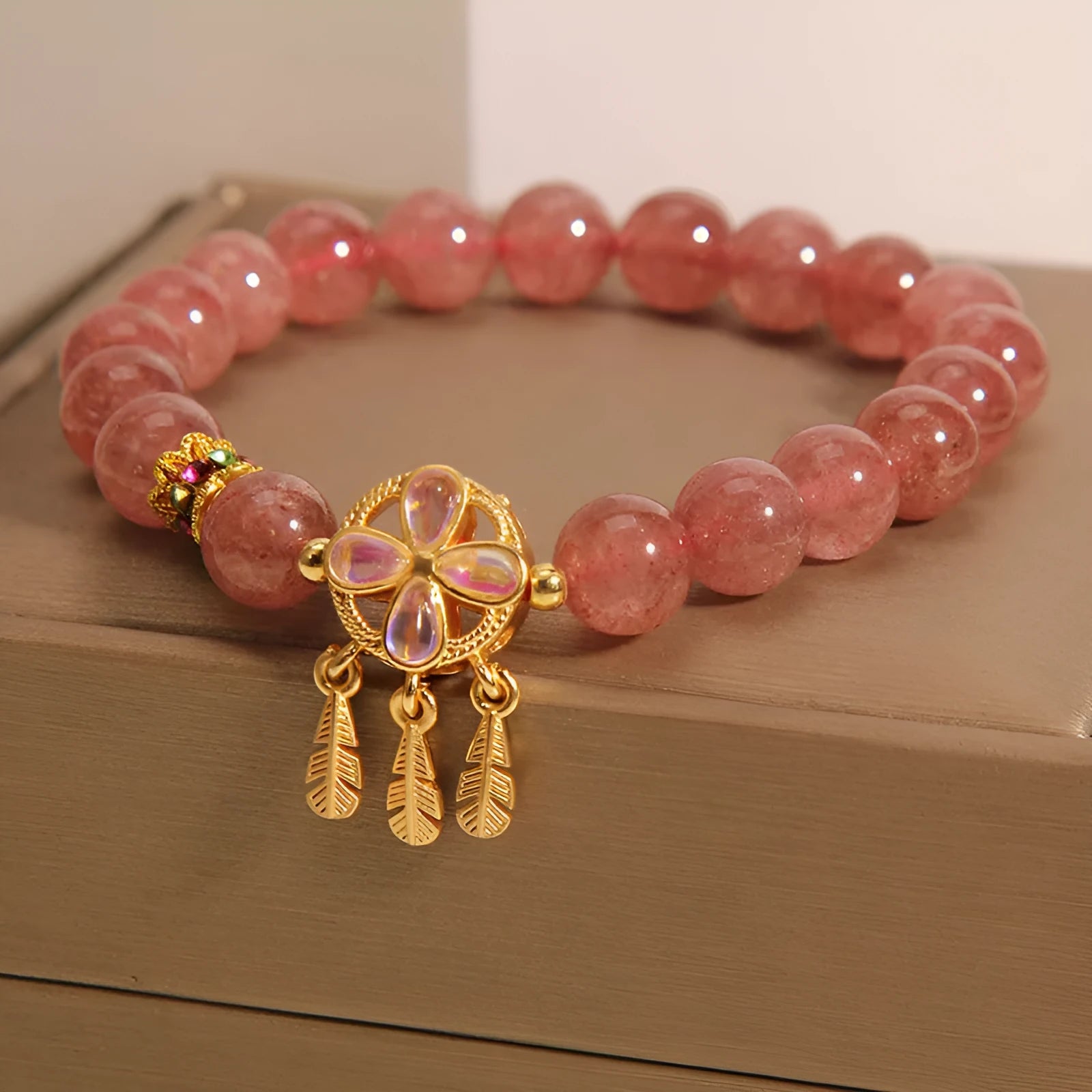 Women's Strawberry Quartz crystal bracelet with a four leaf clover dream catcher ball pendant.
